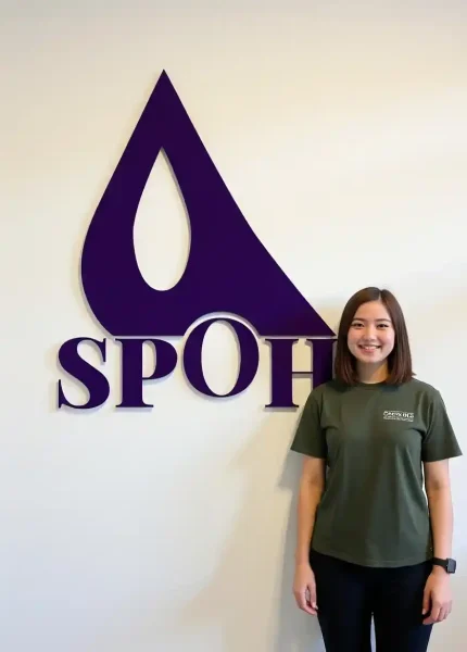 Spohy logosu önünde duran öğrenci, 15 ülkede yurt dışı eğitim danışmanlığı temsilcisi